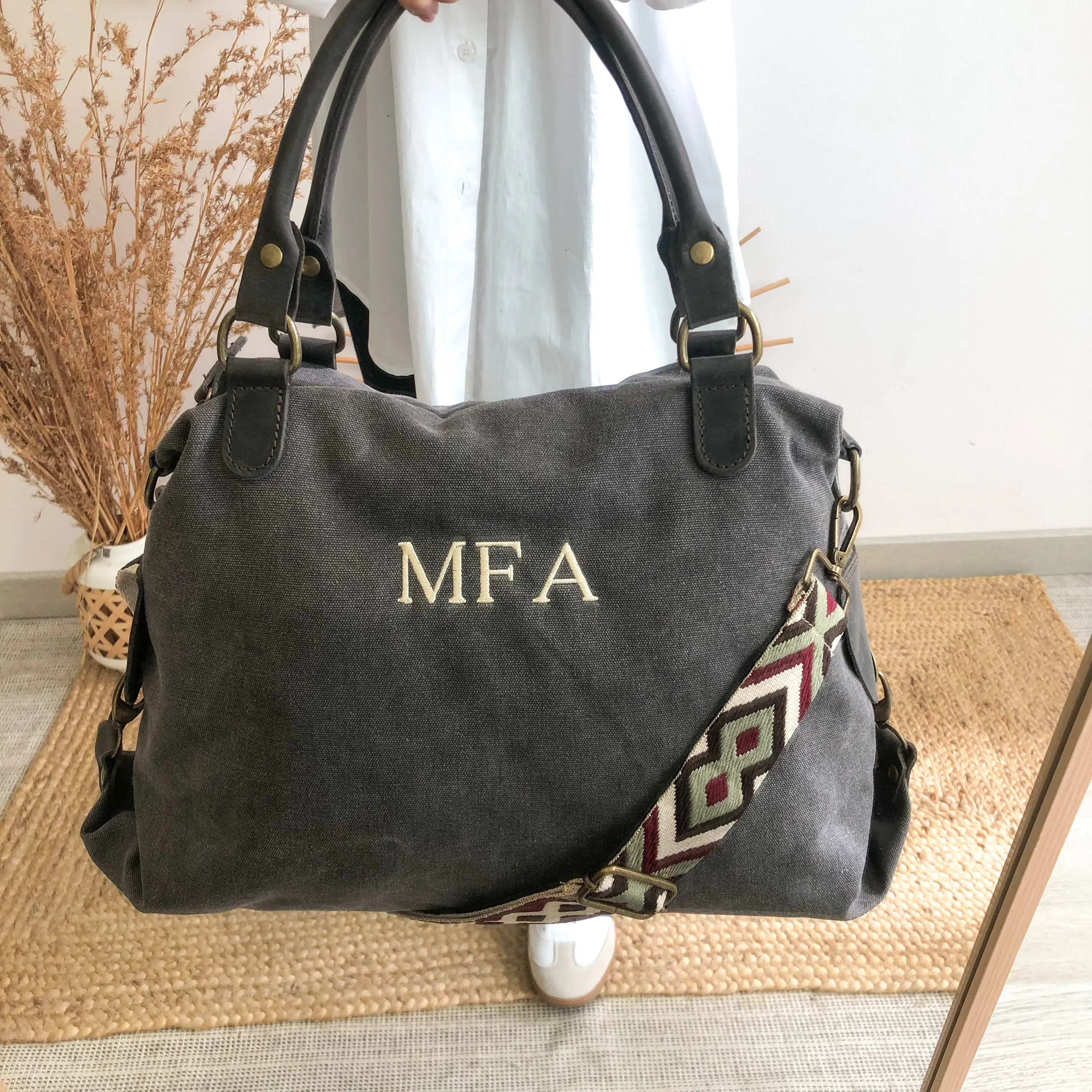 Bolso loneta y piel gris iniciales bordadas con correa étnica