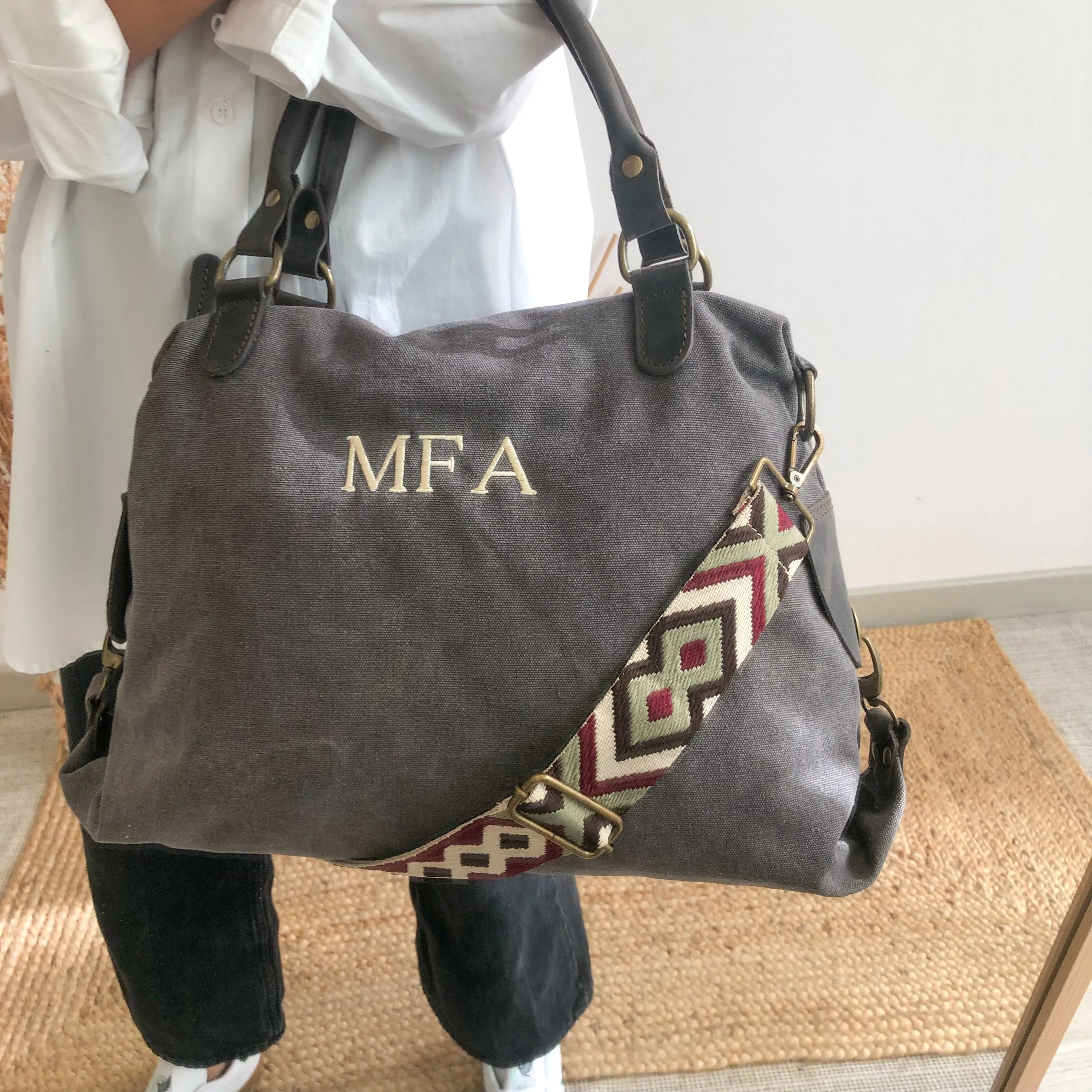 Bolso loneta y piel gris iniciales bordadas con correa étnica