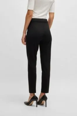 Pantalones regular fit en tejido elástico con corte cónico