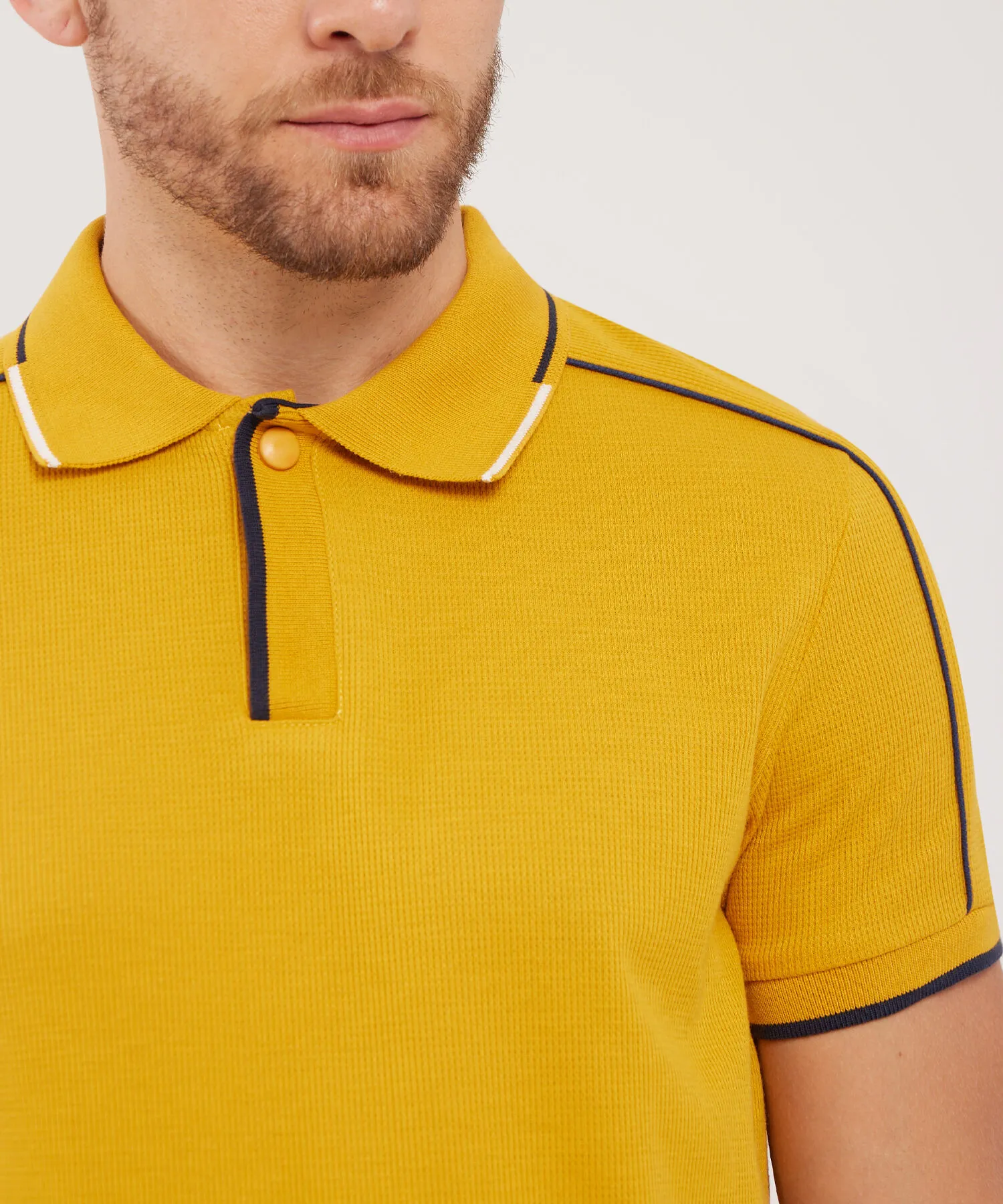 POLO UNICOLOR CON PECHERA TEJIDA Y BROCHE