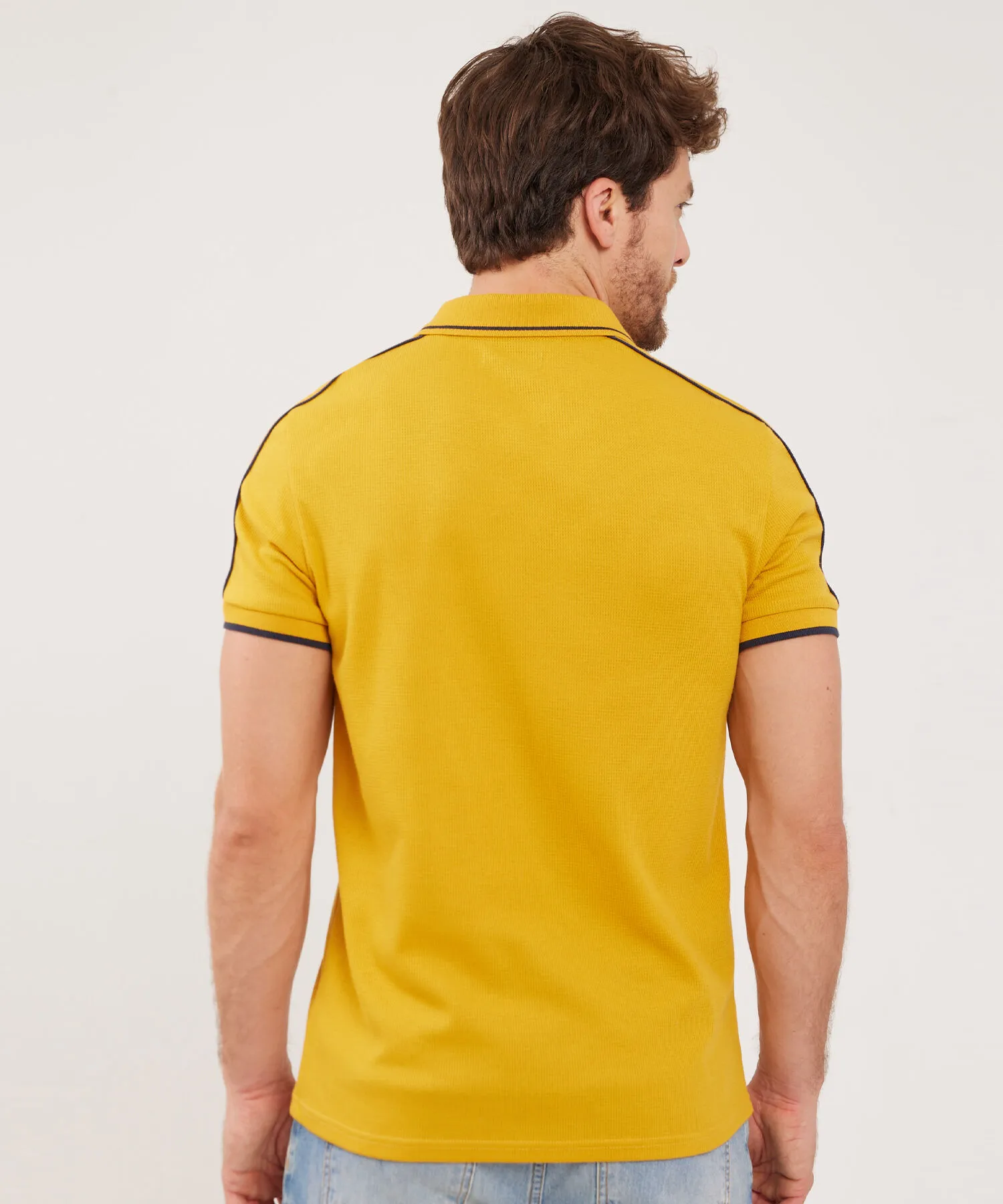 POLO UNICOLOR CON PECHERA TEJIDA Y BROCHE